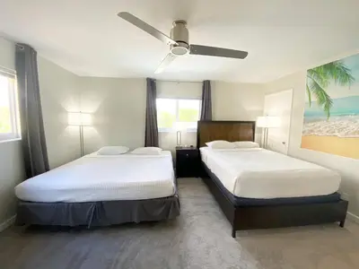 a bedroom with two beds and a ceiling fan at Tarpon Harbor 1 - Waterfront pool home near beach & downtown Las Olas in Fort Lauderdale