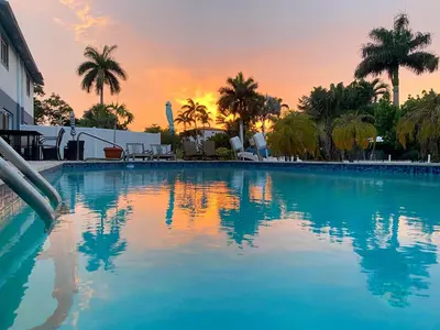 a swimming pool with a sunset in the background at Tarpon Harbor 1 - Waterfront pool home near beach & downtown Las Olas in Fort Lauderdale