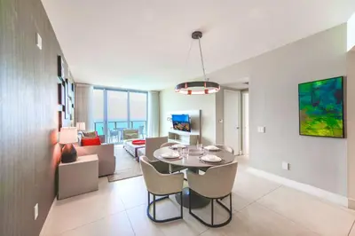 a dining room and living room with a table and chairs at Spectacular Sunset Views Over the Ocean at Hollywood in Hollywood