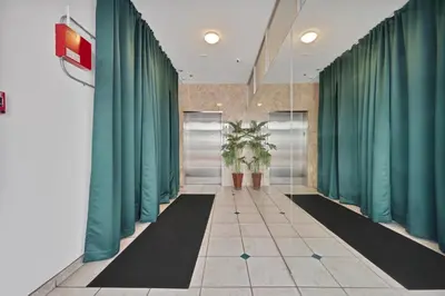 a corridor with green curtains and plants in a building at Sunny Miami Beach Retreat in Miami Beach