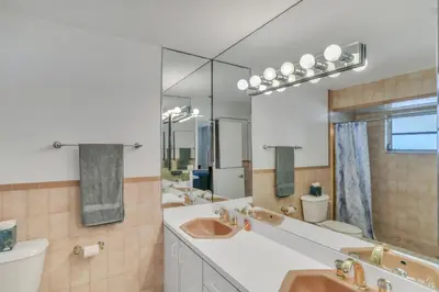 a bathroom with two sinks and two mirrors at MiaBella of Hollywood home in Hollywood