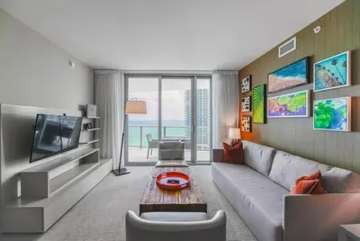 a living room with a couch and a tv at Gorgeous Views Await in Your Beachfront Condo in Hollywood