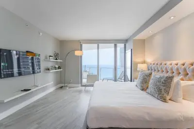 a bedroom with a large bed and a television at Luxury Condo with Oceanfront View in Hollywood in Hollywood