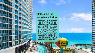 a sign in front of a building next to the ocean at Luxury Condo with Oceanfront View in Hollywood in Hollywood