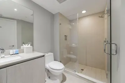 a white bathroom with a toilet and a shower at Luxury Condo with Oceanfront View in Hollywood in Hollywood