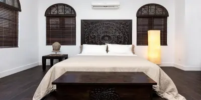 a bedroom with a bed with a table and two windows at Vive Zen Queen Room in Miami