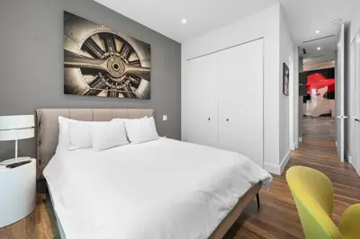 a bedroom with a white bed and a yellow chair at Best Bayfront View New construction w pool in Miami Beach
