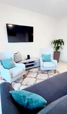 a living room with two chairs and a flat screen tv at Modern Townhouse with terrace! in Homestead