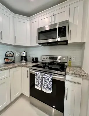 a kitchen with a black stove and a microwave at Modern Townhouse with terrace! in Homestead