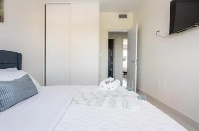 a white bed with a stuffed animal sitting on top of it at Modern Townhouse with terrace! in Homestead