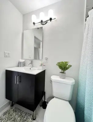a bathroom with a white toilet and a sink at Modern Townhouse with terrace! in Homestead