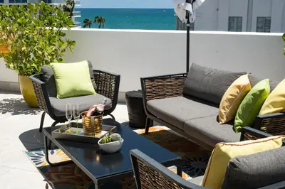 a patio with chairs and a table and a couch at Hotel Croydon in Miami Beach