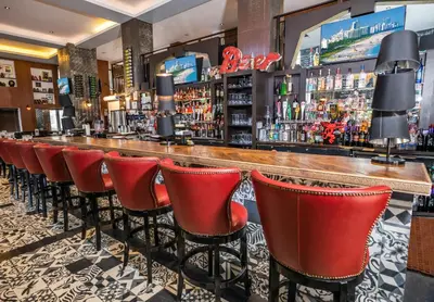 a bar with red bar stools in a restaurant at Hotel Croydon in Miami Beach