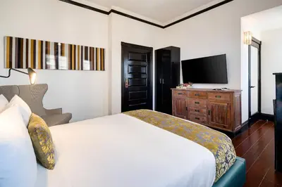 a hotel room with a bed and a television at Hotel Croydon in Miami Beach