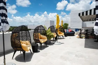 a row of chairs on a rooftop patio at Hotel Croydon in Miami Beach