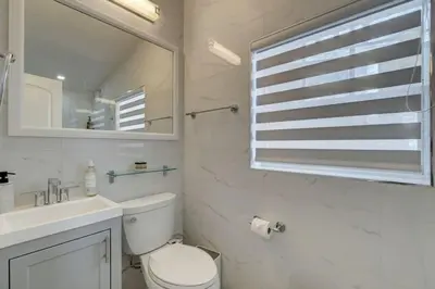a bathroom with a toilet and a sink and a mirror at Laguna @ Casa Del Sol in Fort Lauderdale
