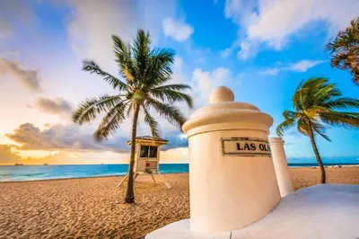 a lighthouse on a beach with a palm tree at Laguna @ Casa Del Sol in Fort Lauderdale