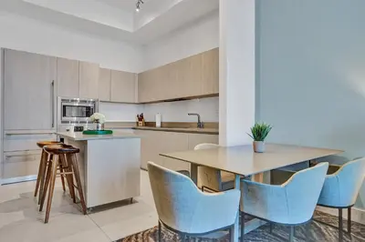 a kitchen with a wooden table and blue chairs at Oceanfront Condo Direct Ocean & Beach Club Access in Hollywood