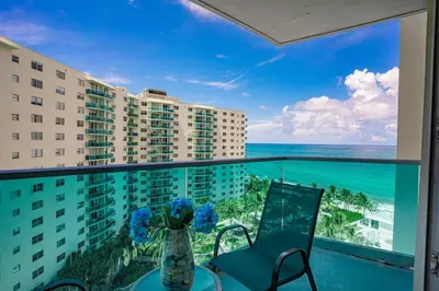 a balcony with a table and chairs and a view of the ocean at Ocean View Modern Condo Beach Access 11M in Hollywood