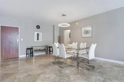 a dining room with a table and white chairs at Ocean View Modern Condo Beach Access 11M in Hollywood