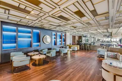 a lobby with tables and chairs in a building at Ocean View Luxury Carillon Condo at Beach Access C616 in Miami Beach