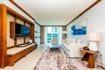 a living room with a white couch and a tv at Ocean View Luxury Carillon Condo at Beach Access C616 in Miami Beach