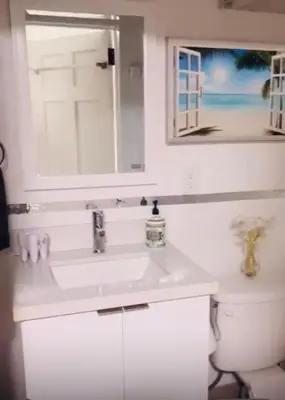 a bathroom with a sink and a window and a toilet at NEW PRIVATE STUDIO MAGIC CITY OF MIAMI, GATED PARKING in Miami