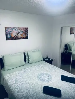 a bedroom with a bed and a painting on the wall at NEW PRIVATE STUDIO MAGIC CITY OF MIAMI, GATED PARKING in Miami