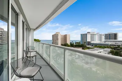 a balcony with two chairs and a view of the ocean at Resort-Style Residence Beachfront Condo Oasis in Fort Lauderdale