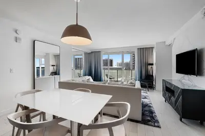 a living room with a white table and chairs at Resort-Style Residence Beachfront Condo Oasis in Fort Lauderdale
