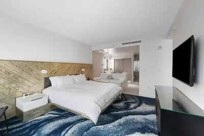 a bedroom with a large bed and a television at Resort-Style Residence Beachfront Condo Oasis in Fort Lauderdale