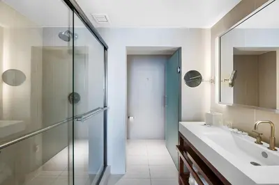 a bathroom with a glass shower and a sink at Resort-Style Residence Beachfront Condo Oasis in Fort Lauderdale