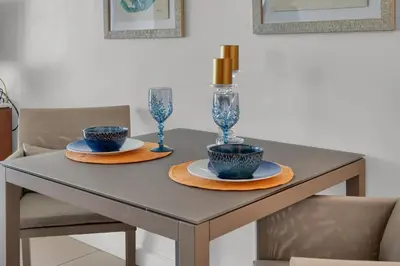 a table with two blue bowls and glasses on it at Beautiful Blue & Gold Studio With Ocean View in Miami