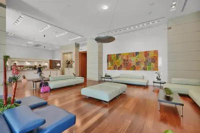 a waiting room with couches and tables in a building at Beautiful Blue & Gold Studio With Ocean View in Miami