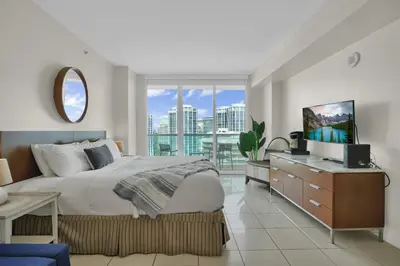 a bedroom with a large bed and a large window at Beautiful Blue & Gold Studio With Ocean View in Miami