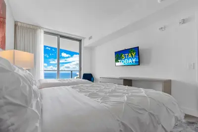 a white bedroom with a large bed and a window at Heaven Resort - 2BDR BEACH HOME WITH OCEAN VIEW HOLLYWOOD! in Hollywood