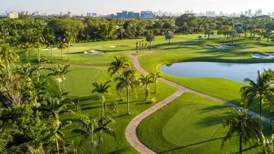 an aerial view of a golf course with palm trees and a pond at Oceanview Private Penthouse Condo at The Setai -3903 in Miami Beach