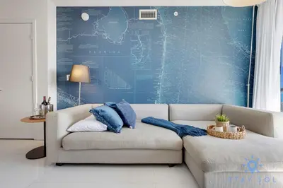 a living room with a couch and a blue wall at Infinite View - Balcony - Gym - Pool in Hallandale Beach