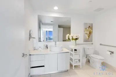 a white bathroom with a sink and a toilet at Infinite View - Balcony - Gym - Pool in Hallandale Beach