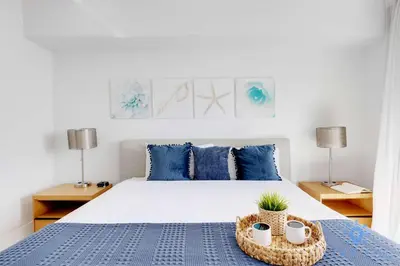a bedroom with a large bed with blue pillows at Infinite View - Balcony - Gym - Pool in Hallandale Beach