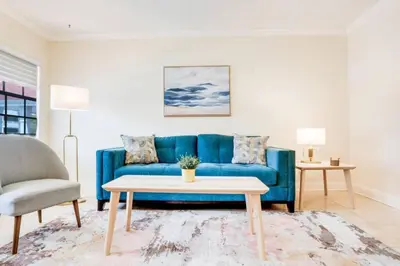 a living room with a blue couch and a table at Intracoastal Oasis in a Prime Area w Pool and BBQ in Fort Lauderdale