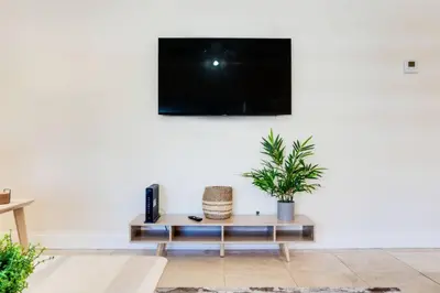 a living room with a tv on a white wall at Intracoastal Oasis in a Prime Area w Pool and BBQ in Fort Lauderdale