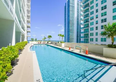 a swimming pool in the middle of a building with tall buildings at Stunning 1/1 Condo @Brickell Free Parking/Pool in Miami