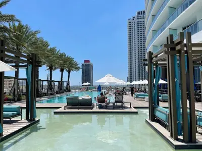 a swimming pool with palm trees and a building at Direct Oceanfront Condo - Hyde Resort in Hollywood
