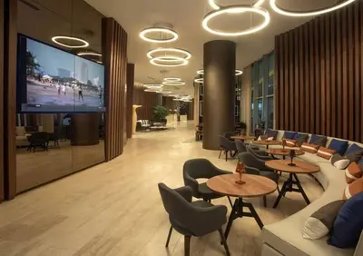 a lobby with tables and chairs and a flat screen tv at Direct Oceanfront Condo - Hyde Resort in Hollywood