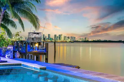 a swimming pool next to the water with a city skyline at Best Sunset View on the Bay with Pool in Miami Beach