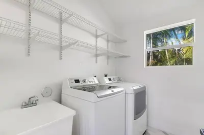 a white laundry room with a washer and a window at Best Sunset View on the Bay with Pool in Miami Beach