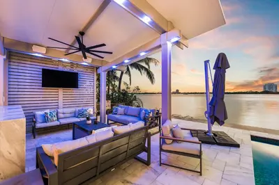 a patio with couches and a tv and a pool at Best Sunset View on the Bay with Pool in Miami Beach