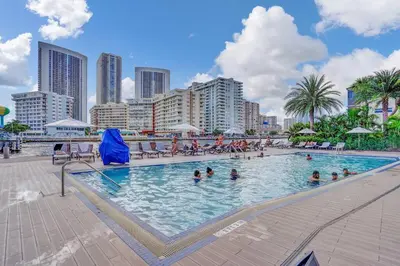 a large swimming pool with people in a city at Lovely 3 bedroom 3 bathroom ocean front in Hallandale Beach