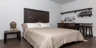 a bedroom with a bed and a table with a headboard at Vive Zen Queen Room in Miami
